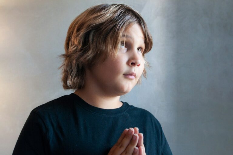 A thoughtful boy looks upward.